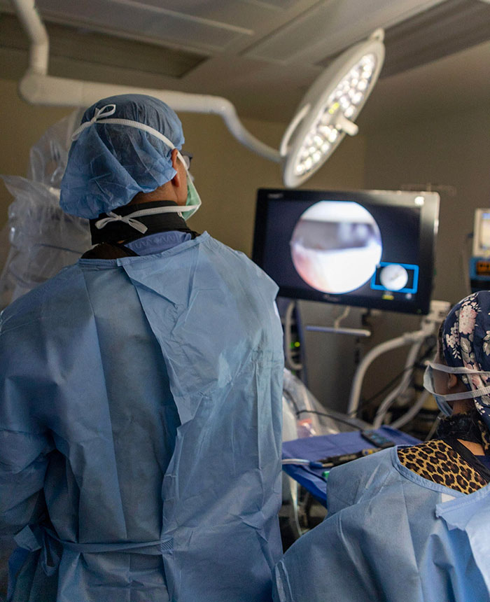 Dr. Hommen views the arthroscopy monitor to view the hip during a labrum repair.